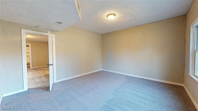 carpeted spare room with a textured ceiling