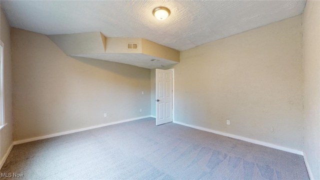 carpeted spare room featuring a textured ceiling