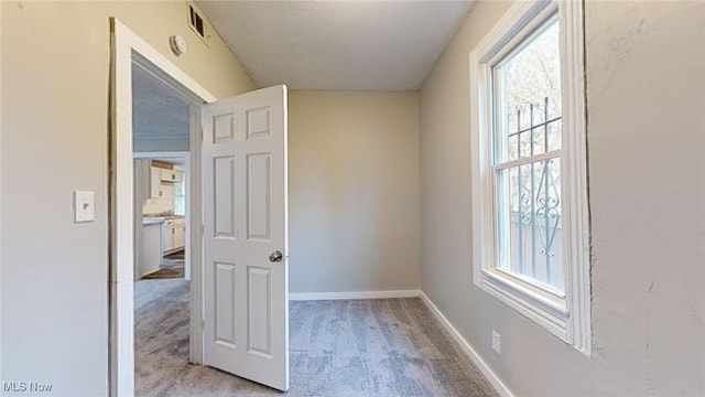 carpeted spare room with a healthy amount of sunlight