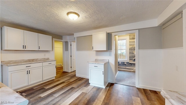 kitchen featuring dark hardwood / wood-style floors, white cabinetry, and a textured ceiling