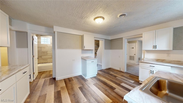 kitchen with white cabinets and a textured ceiling