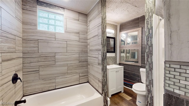 full bathroom featuring sink, tiled shower / bath combo, a textured ceiling, toilet, and hardwood / wood-style flooring