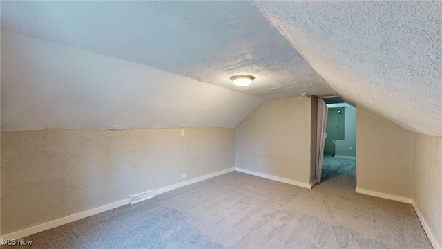 bonus room featuring a textured ceiling, carpet floors, and vaulted ceiling