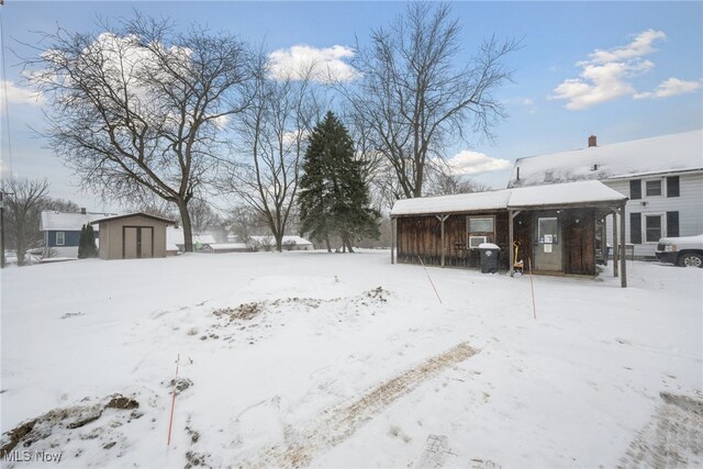 yard covered in snow with a storage unit