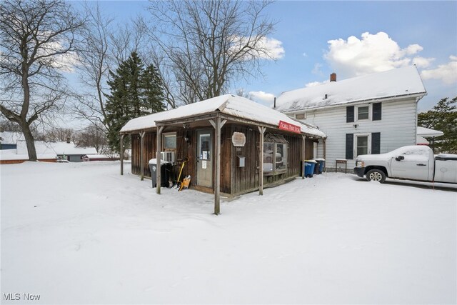 view of snow covered rear of property