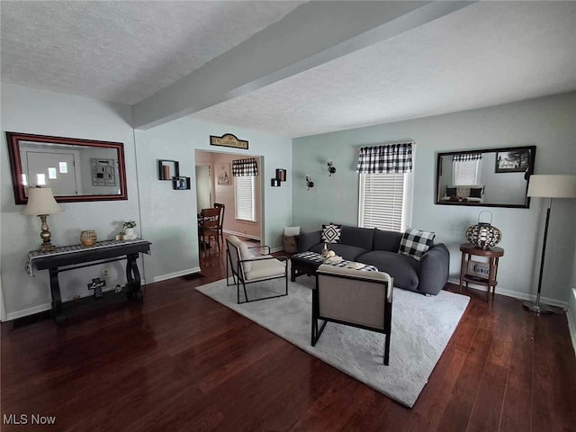 living room with beamed ceiling, a textured ceiling, and dark hardwood / wood-style flooring