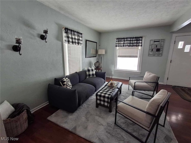 living room featuring dark hardwood / wood-style flooring and a textured ceiling