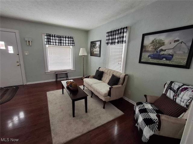 living room with a healthy amount of sunlight, dark hardwood / wood-style flooring, and a textured ceiling