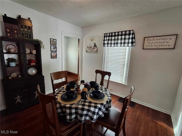 dining space featuring baseboards and wood finished floors