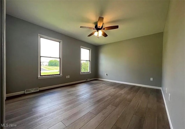 spare room with ceiling fan and dark hardwood / wood-style flooring