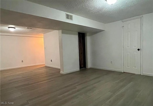 basement with a textured ceiling and hardwood / wood-style flooring