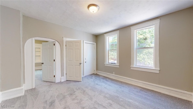 unfurnished bedroom with light carpet and a closet