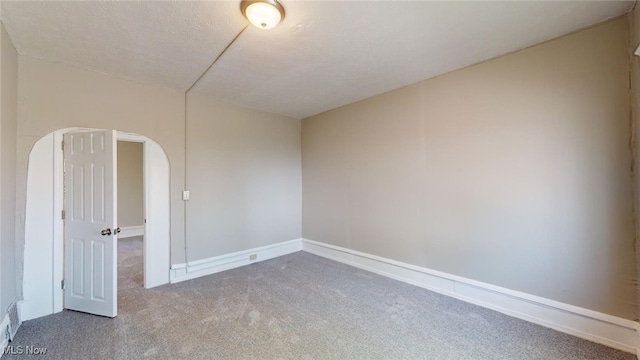 empty room featuring carpet and a textured ceiling