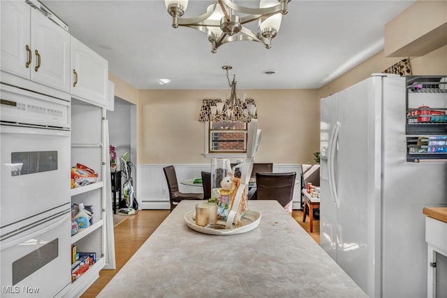 dining room with a baseboard radiator, an inviting chandelier, and dark wood-type flooring