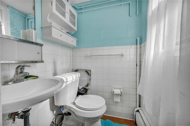 bathroom featuring baseboard heating, hardwood / wood-style flooring, tile walls, and toilet