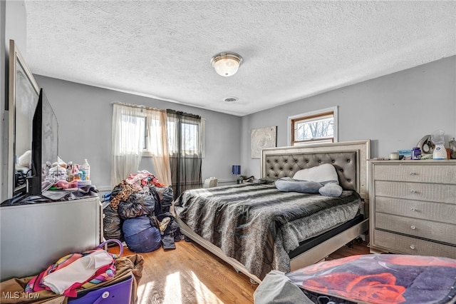 bedroom featuring a textured ceiling and hardwood / wood-style flooring