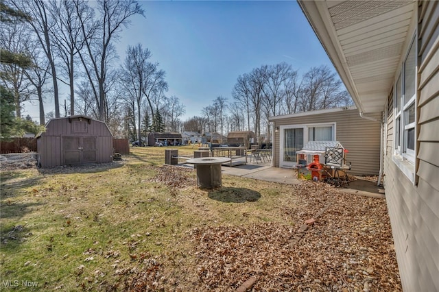 view of yard with a patio area, a shed, and an outdoor fire pit