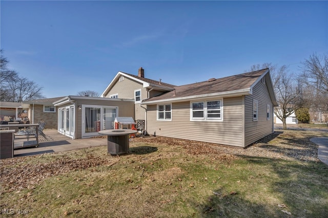 rear view of house with a patio and a lawn