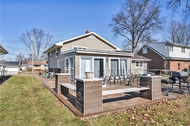 rear view of house featuring a lawn and central air condition unit