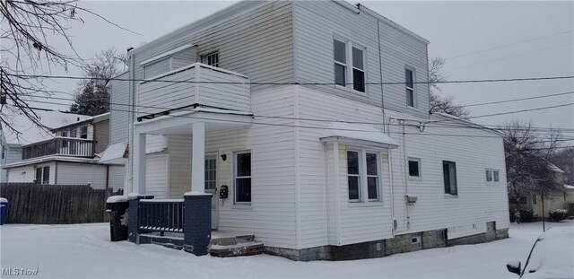 view of snowy exterior with a balcony