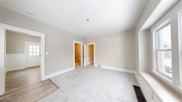 carpeted empty room featuring plenty of natural light