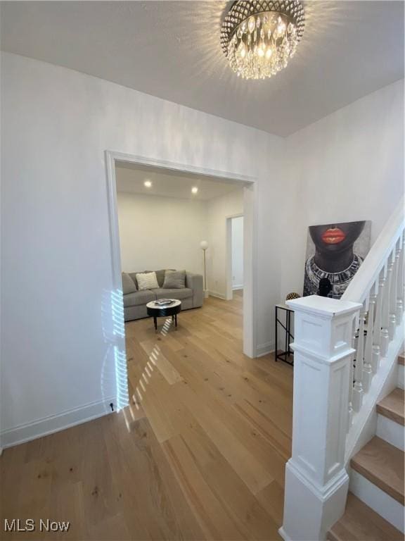 corridor featuring a chandelier and light hardwood / wood-style flooring