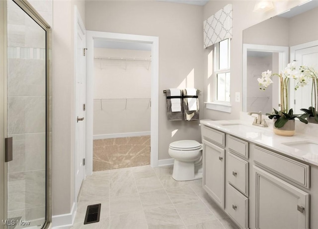 bathroom featuring vanity, toilet, and a shower with door