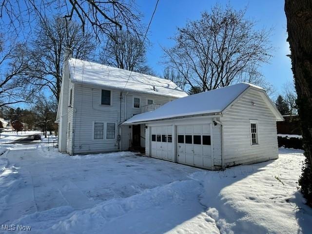 view of front of home featuring a garage and an outbuilding