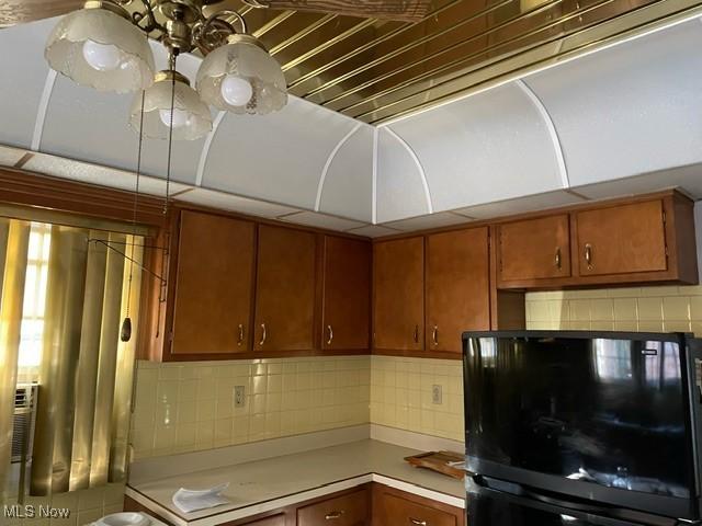 kitchen featuring decorative backsplash and black fridge