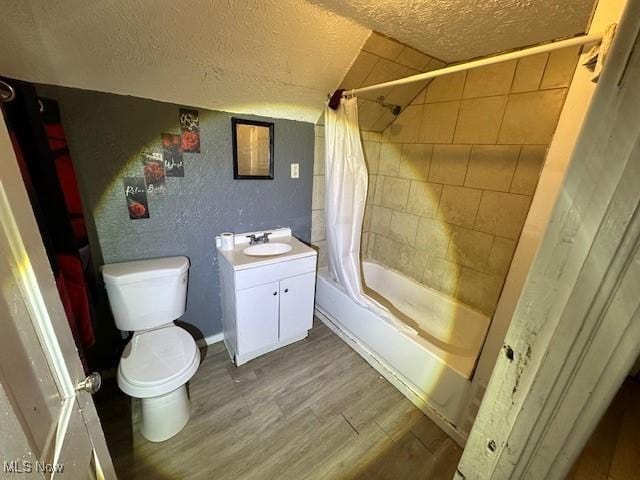 full bathroom featuring shower / bath combination with curtain, toilet, wood-type flooring, and a textured ceiling