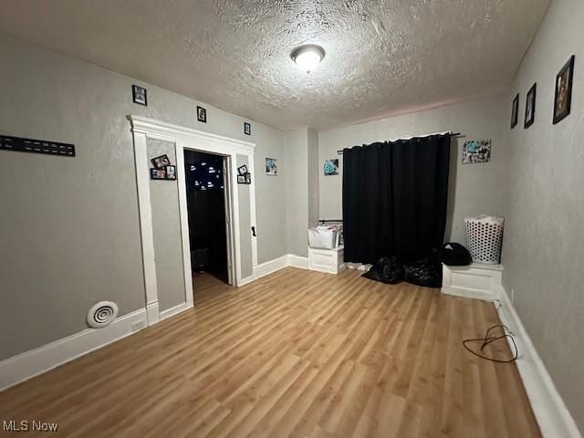 interior space with a textured ceiling and hardwood / wood-style flooring