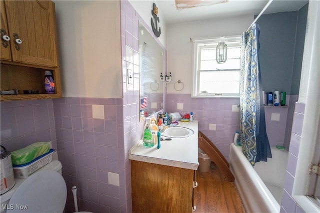 full bathroom with shower / tub combo, vanity, tile walls, and toilet