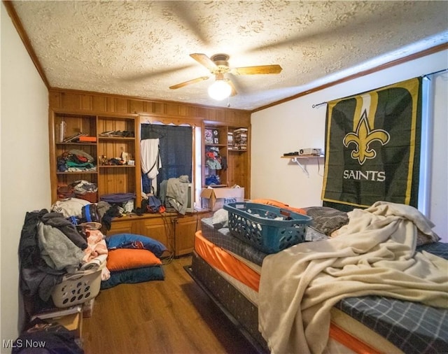 bedroom with ceiling fan, hardwood / wood-style floors, and a textured ceiling