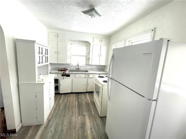 kitchen featuring white appliances, white cabinets, sink, a textured ceiling, and dark hardwood / wood-style flooring