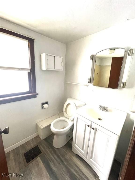 bathroom with hardwood / wood-style floors, vanity, and toilet