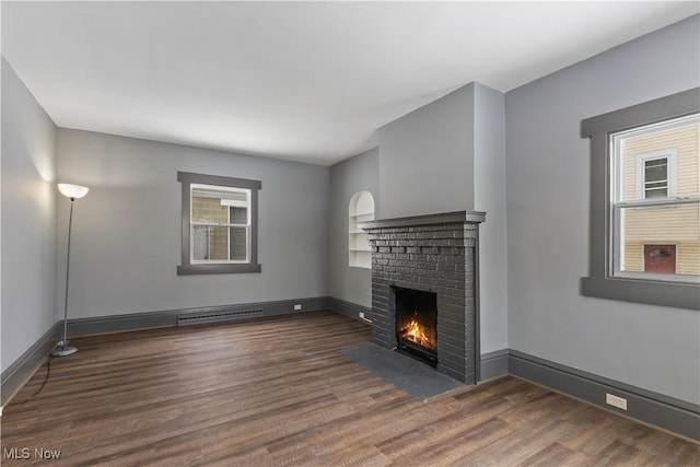 unfurnished living room featuring a fireplace and dark wood-type flooring