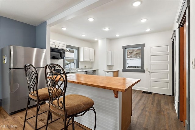 kitchen with white cabinetry, sink, stainless steel appliances, dark wood-type flooring, and wooden counters