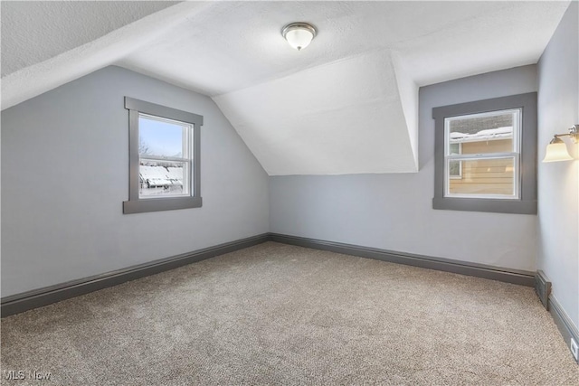 bonus room with carpet flooring, plenty of natural light, a textured ceiling, and vaulted ceiling