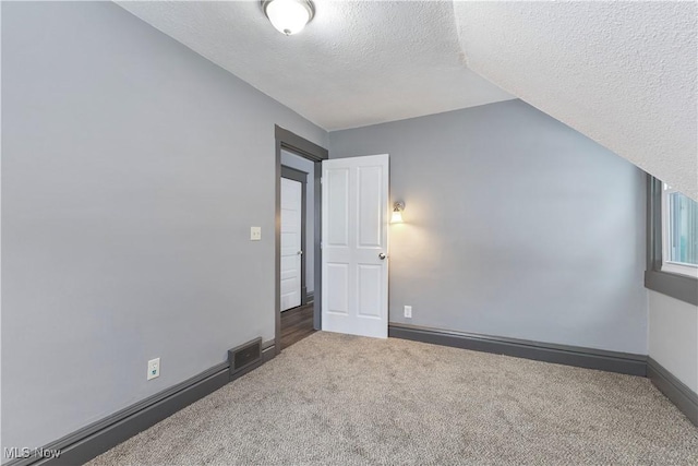 interior space featuring carpet flooring and a textured ceiling