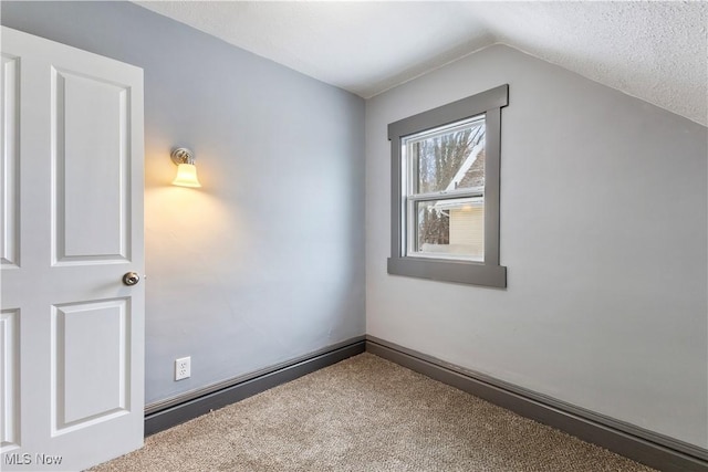 additional living space with a textured ceiling, carpet flooring, and vaulted ceiling