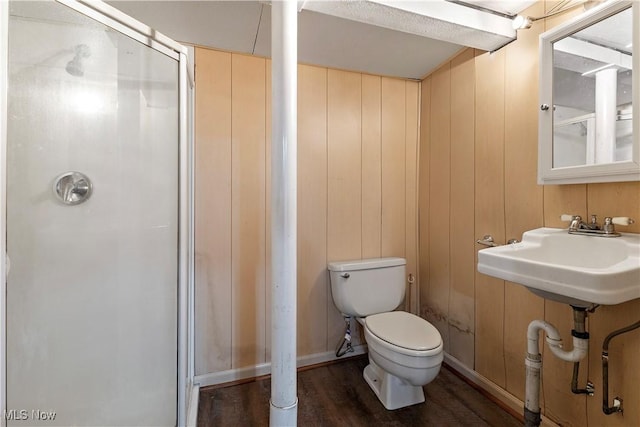 bathroom featuring wood walls, toilet, and sink