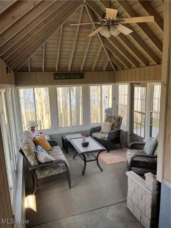 sunroom / solarium with vaulted ceiling with beams, ceiling fan, and wooden ceiling