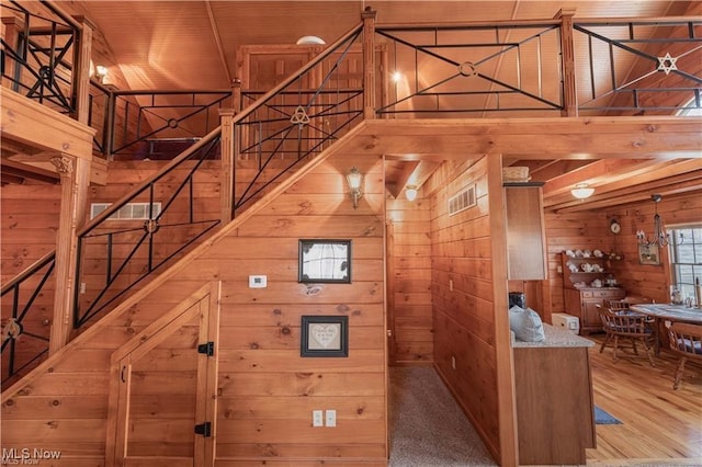 interior space with carpet flooring, wooden walls, and wood ceiling