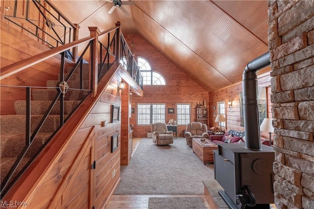 unfurnished living room featuring ceiling fan, wood walls, and wood ceiling