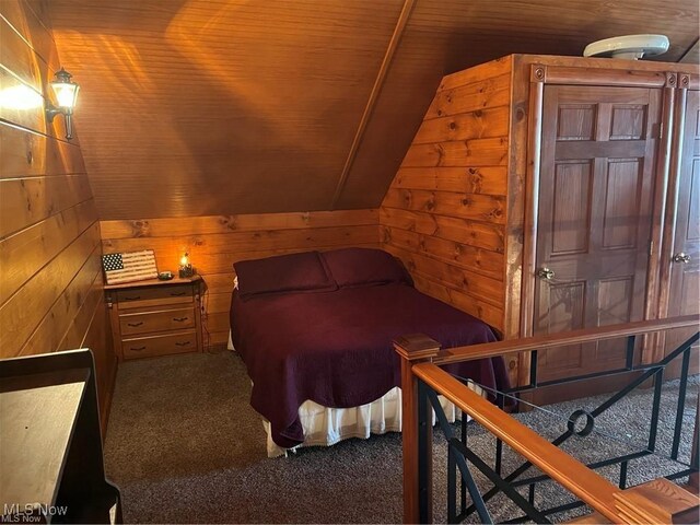 bedroom with wooden walls, wooden ceiling, lofted ceiling, and dark colored carpet