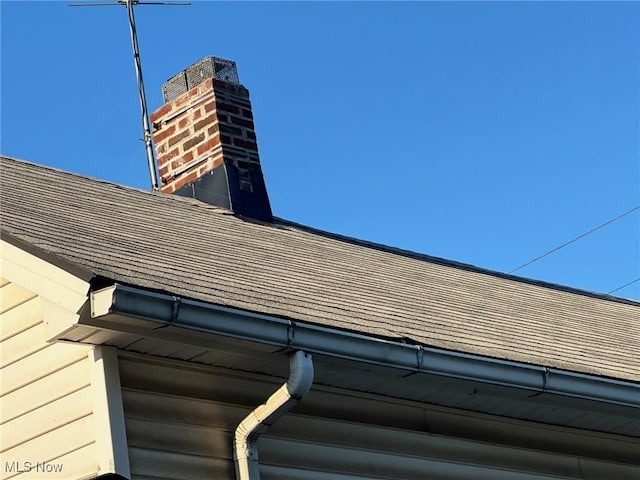 3978 E 89th St, Cleveland, OH 44105 - exterior view of roof with shingles, a downspout, gutters, and a chimney