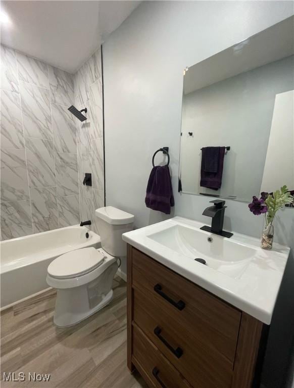 full bathroom featuring vanity, hardwood / wood-style flooring, toilet, and tiled shower / bath