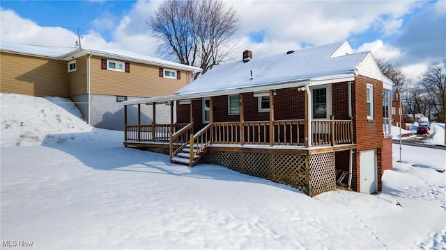 snow covered house with a garage