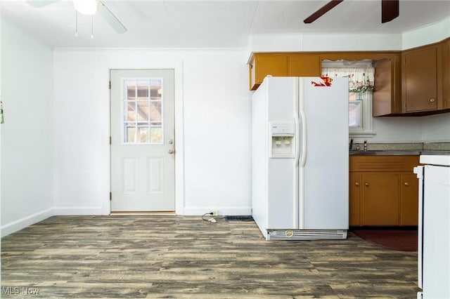 kitchen with white fridge with ice dispenser and dark wood-type flooring