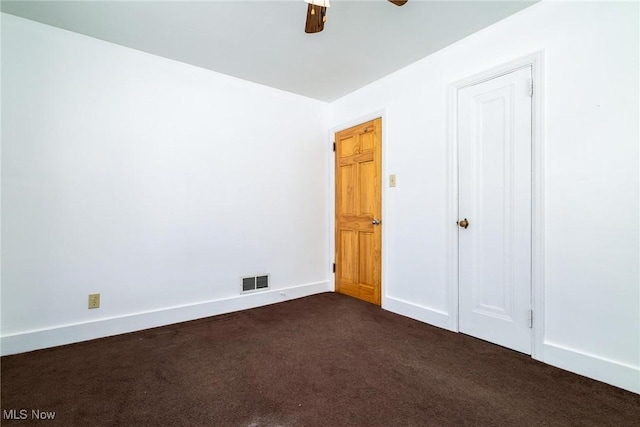 unfurnished bedroom with ceiling fan and dark colored carpet